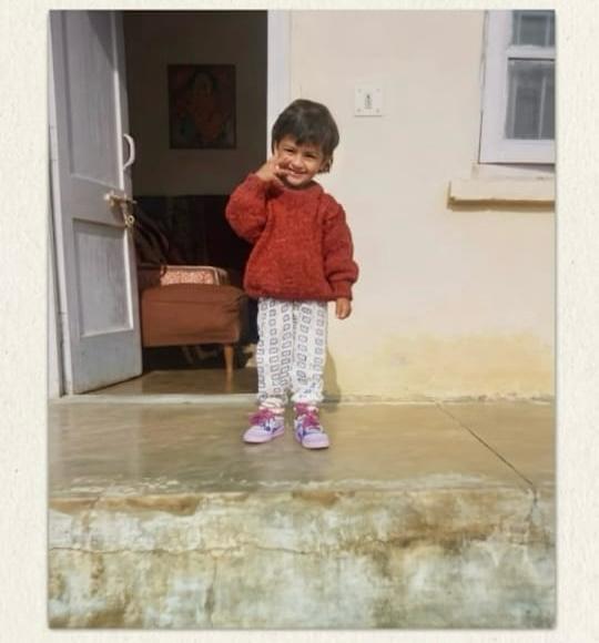A childhood photograph of Rinsha smiling on a doorstep
